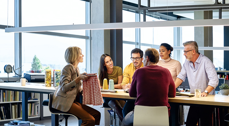 Business people discussing over fabric at table